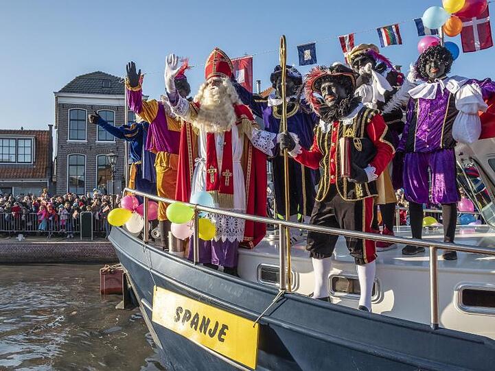 Menschen beobachten in Monnickendam die traditionelle Ankunft von Sinterklaas (Nikolaus) und Zwarte Piet ("Schwarzer Peter") mit einem Dampfschiff.