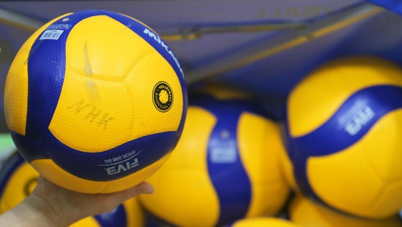 Volleybälle liegen in einer Halle.