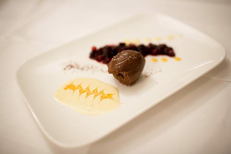 5. GANG: Ganache au chocolat &ndash; Beerencoulis &ndash; Vanillesauce. Oh la la, wie betörend! Diese verführerisch glänzende Schokoladencreme hält alle Erwartungen am Gaumen. Ihre Begleiter, die lässige Vanillesauce und die Beeren, sind so viel mehr als nur bildschöne Verzierungen auf dem Teller. Damit ist genug gesagt. Der Banyuls, Jahrgang 2010, ein französischer Likörwein, rundet dieses Menü ab.
