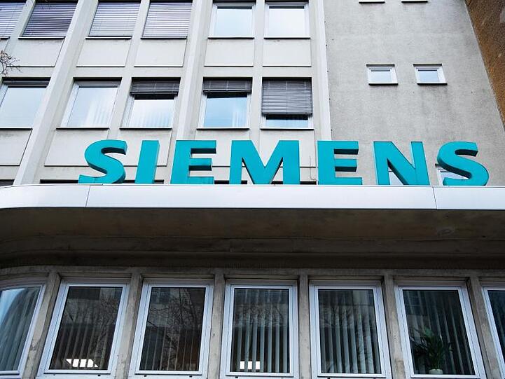 Der Schriftzug "Siemens" neben dem Eingangstor des Unternehmens in der Huttenstraße, Berlin. Siemens Energy will die Zahl seiner weltweiten Fertigungsstandorte reduzieren.