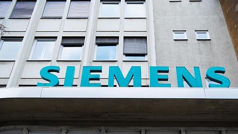 Der Schriftzug "Siemens" neben dem Eingangstor des Unternehmens in der Huttenstraße, Berlin. Siemens Energy will die Zahl seiner weltweiten Fertigungsstandorte reduzieren.
