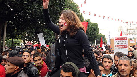 In Tunesien feiern junge Menschen den Sturz Ben Alis. Der Arabische Frühling nahm dort im Dezember 2010 seinen Anfang.