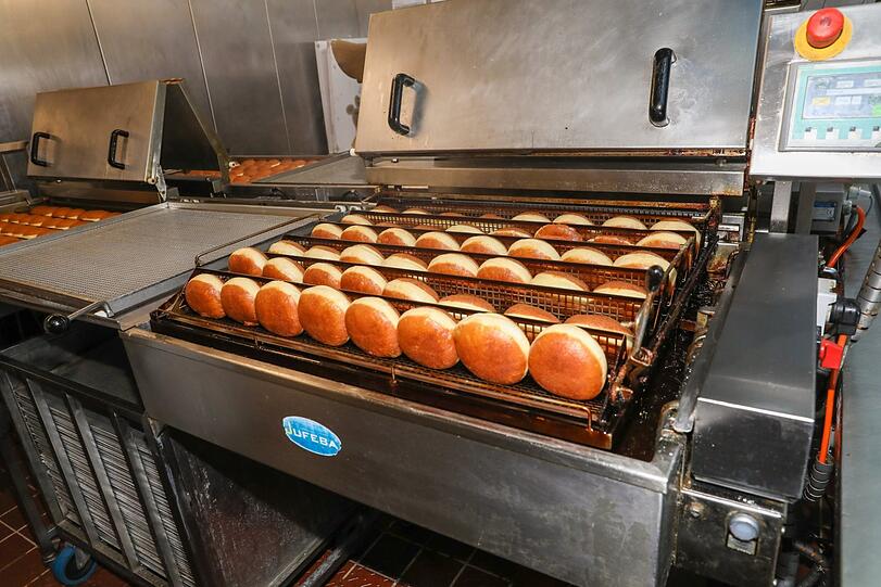 Die Fritteusen wenden die Krapfen mehrmals automatisch. Fertig sind sie, wenn sie schön goldbraun sind. Nach exakt 5 Minuten und 25 Sekunden.
