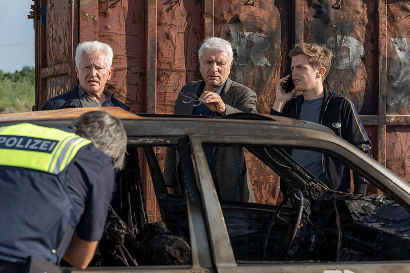Batic (Miroslav Nemec, links), Leitmayr (Udo Wachtveitl, Mitte) und Kalli inspizieren den verbrannten Wagen, der nach der Tat aufgefunden wird.