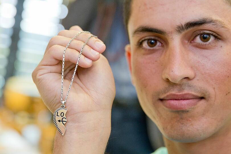 Der 16-jährige Imran aus Afghanistan hält während der Vorbereitungen zur Ausstellung "Stories of my Life" im Museum im Kulturspeicher in Würzburg einen Herzanhänger in der Hand. Der Anhänger ist alles, was ihm von Hause geblieben ist.