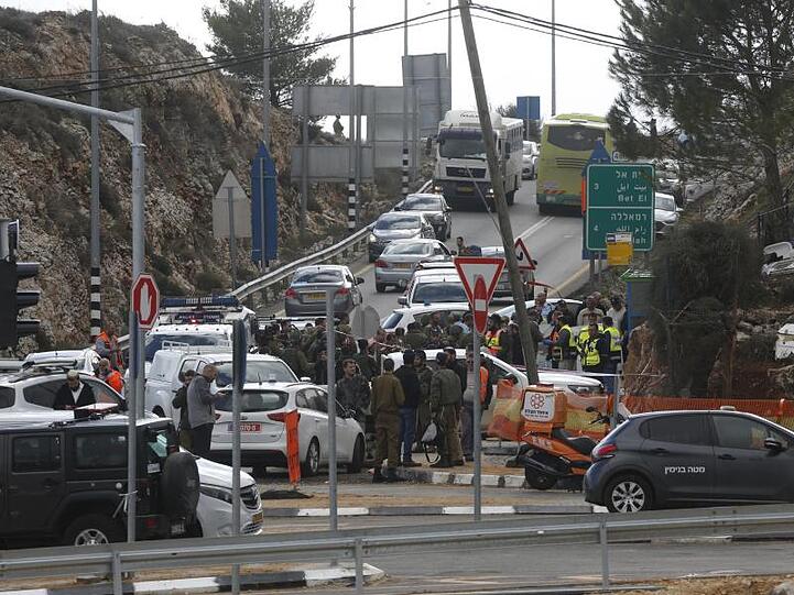 Israelische Soldaten und Mitarbeiter des Rettungsdienstes stehen am Ort des Anschlags.