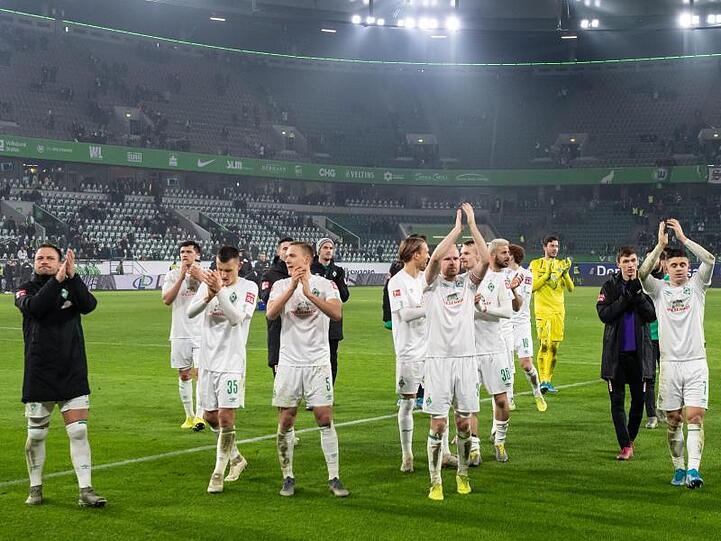 Die Spieler von Werder Bremen feiern den Sieg in Wolfsburg vor ihrer Fankurve.