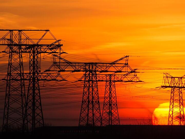 Die Sonne geht hinter Hochspannungsleitungen auf. Foto: Klaus-Dietmar Gabbert/dpa-Zentralbild/dpa/Archivbild