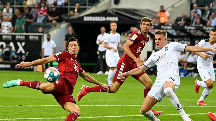 Münchens Robert Lewandowski (l) und Mönchengladbachs Matthias Ginter kämpfen um den Ball.
