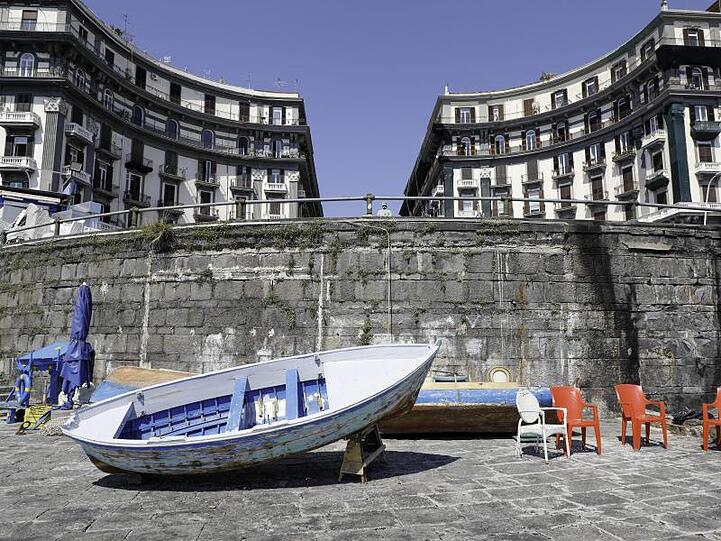 Fischerboote liegen in einem menschenleeren Hafen in Neapel, Italien.