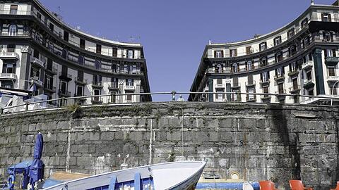 Fischerboote liegen in einem menschenleeren Hafen in Neapel, Italien.