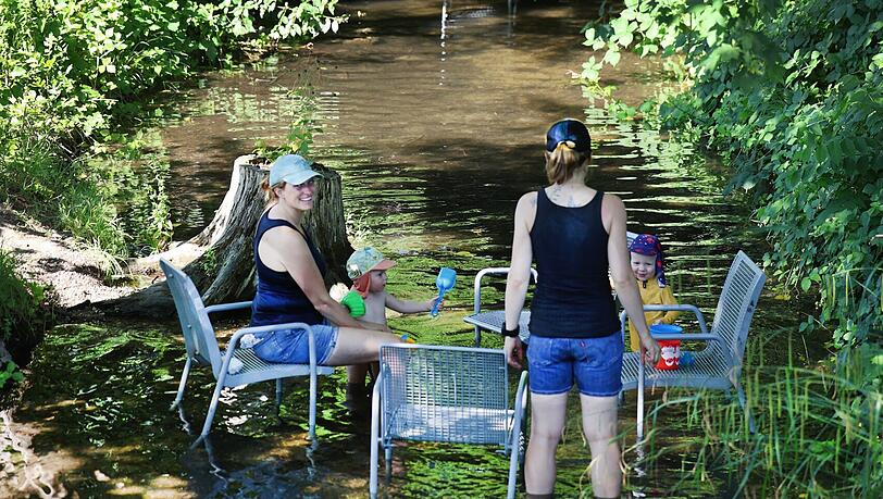 Das Freibadbächl fließt leise durch den Rosengarten. Im Sommer stehen die metallenen Stühle, die sonst am Weg oder auf der Wiese stehen, im Wasser – hervorragend, um die Füße abzukühlen und mit den Kindern zu planschen.