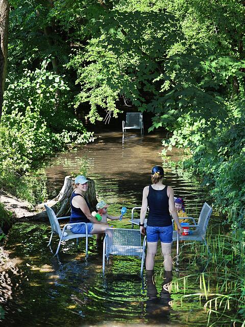 Das Freibadbächl fließt leise durch den Rosengarten. Im Sommer stehen die metallenen Stühle, die sonst am Weg oder auf der Wiese stehen, im Wasser – hervorragend, um die Füße abzukühlen und mit den Kindern zu planschen.
