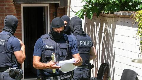 Bundespolizisten stehen vor einer Wohnung. Foto: Ralf Roeger