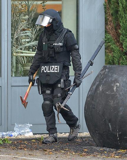 Mit erhobenen Händen kommt ein Mann auf die SEK-Beamten zu, im Hintergrund lauern Heckenschützen der Polizei. Die Beamten nehmen den Mann fest, es ist aber nicht der Täter, der sich in einem Imbiss in Freiburg veschanzt hat.