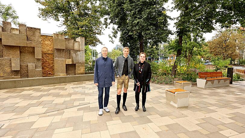 v. l. Mobilitätsreferent Georg Dunkel, Bürgermeister Dominik Krause und Baureferentin Jeanne-Marie Ehbauer vor dem Brunnen auf dem Platz vor dem Oskar-von-Miller-Forum. v. l. Mobilitätsreferent Georg Dunkel, Bürgermeister Dominik Krause und Baureferentin Jeanne-Marie Ehbauer vor dem Brunnen auf dem Platz vor dem Oskar-von-Miller-Forum.