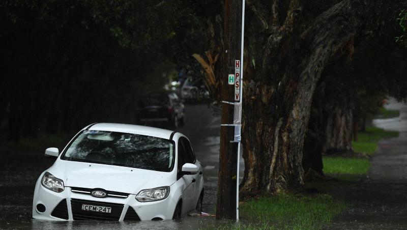 Ein Auto steht in einer überfluteten Straße in Sydney. Schwere Unwetter haben weite Teile Australiens heimgesucht.