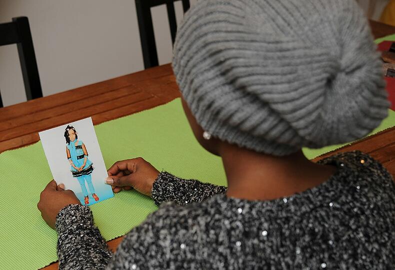 Ayan betrachtet ein Bild ihrer Tochter Amira. Sie will ihr Gesicht nicht zeigen - aus Angst, dass ihr dann noch weiters Leid widerfahren könnte.