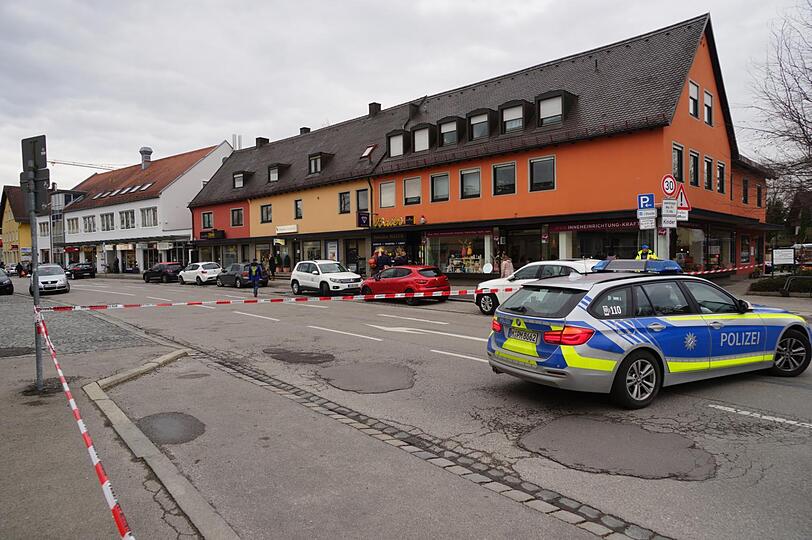 Das Geschäft des Juweliers befindet sich hinter dem roten Auto. In dem abgesperrten Bereich werden die Projektile gesichert.