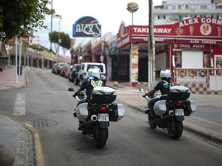 Polizisten überwachen die Lokalsperrungen auf einer Straße in der Touristenhochburg Magaluf.