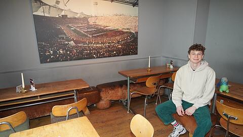 Dennis arbeitet im München 72. Bevor die ersten Gäste kommen, nimmt er auch mal auf einem Bock Platz und lacht in die Kamera. Sein Chef möchte nicht aufs Bild.