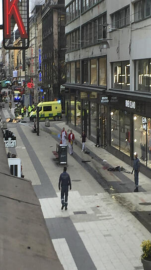 Rettungskräfte sind in einer Einkaufsstrasse in Stockholm zu sehen. Ein Kleinlaster ist Medienberichten zufolge in der Stockholmer Königinstraße in eine Menschenmenge und dann in ein Kaufhaus gerast. Die Polizei spricht von Terrorverdacht.