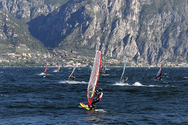 Windsurfer surfen bei starkem Wind auf dem Gardasee bei Malcesine.