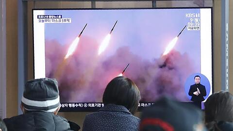 Menschen verfolgen in einem Bahnhof in Seoul eine Nachrichtensendung, die über einen Raketentest von Nordkorea berichtet.