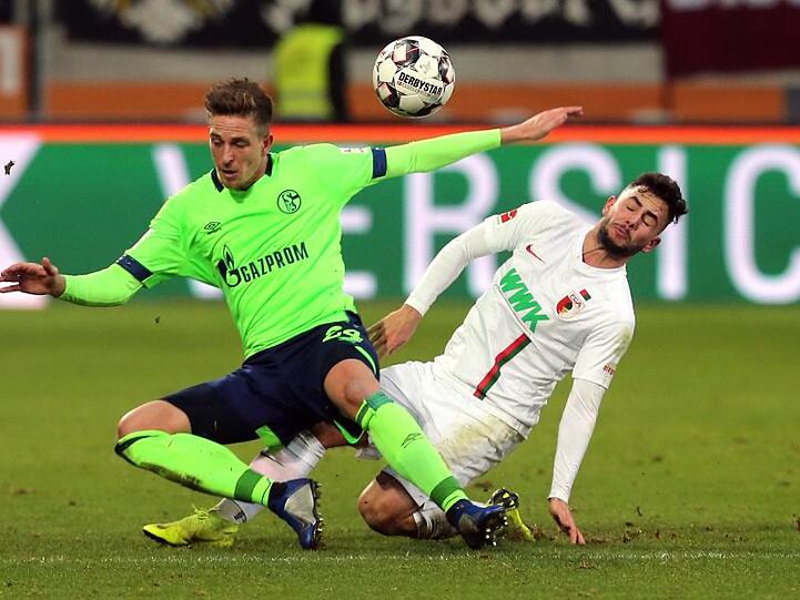 Schalkes Bastian Oczipka und Augsburgs Marco Richter (l-r.) im Zweikampf um den Ball. Foto: Karl-Josef Hildenbrand