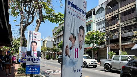 Wahlplakate sind an einer Straße aufgehängt. Am Sonntag wählt Thailand ein neues Parlament. Die Opposition liegt bei Umfragen vorne.