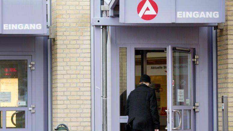Ein Mann geht in ein Gebäude der Agentur für Arbeit. Foto: Christian Charisius/Archiv