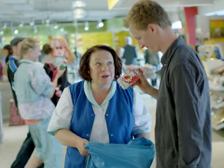 Martina Eitner-Acheampong spielt im neuen Müllermilch-Werbespot eine Supermarkt-Mitarbeiterin