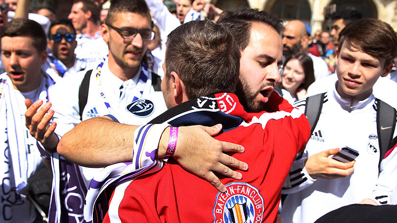 Weiß trifft Rot: Ein Bayern-Fan umarmt auf dem Marienplatz einen Madrilenen.