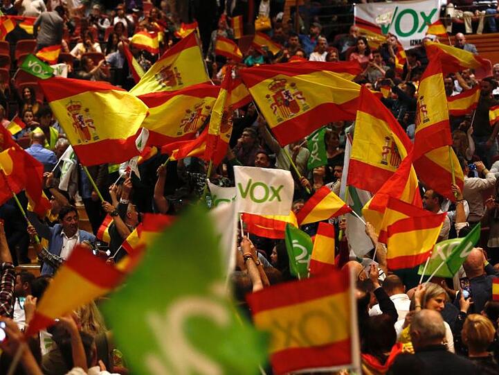 Vox-Unterstützer schwenken Fahnen während einer Wahlkampfveranstaltung mit Abascal, dem Vorsitzenden der rechtsextremen Partei.