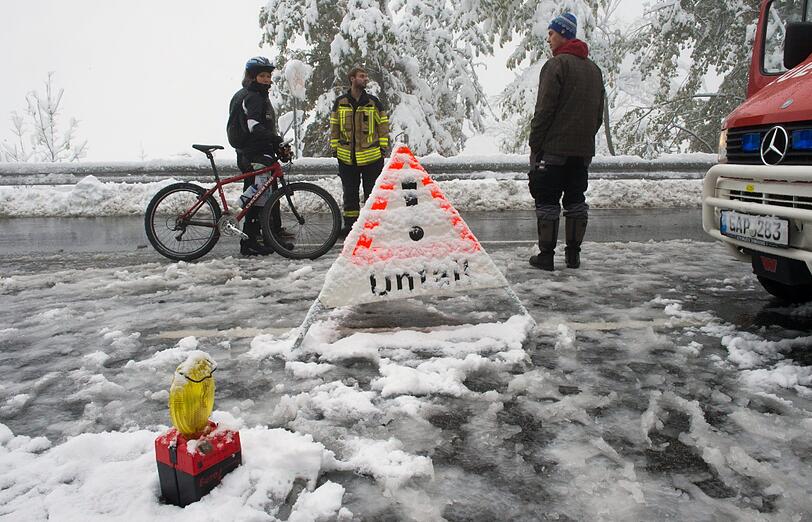 Sperre! Drei Männer stehen auf der Bundesstraße B2 zwischen Garmisch-Partenkirchen und Klais (Bayern) auf einer verschneiten und gesperrten Straße.