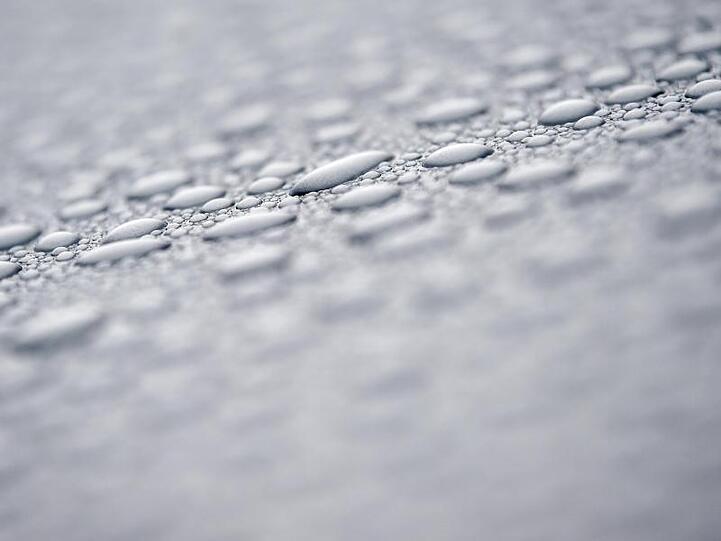 Nach einem Regenschauer perlen Wassertropfen auf dem Lack eines Autos. Foto: Patrick Pleul/dpa-Zentralbild/dpa/Symbolbild
