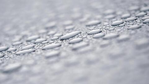 Nach einem Regenschauer perlen Wassertropfen auf dem Lack eines Autos. Foto: Patrick Pleul/dpa-Zentralbild/dpa/Symbolbild