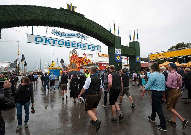 Trotz Sauwetter und Regen warten bereits viele Wiesngänger auf den Wiesnanstich. Der Kampf um den Platz im Bierzelt beginnt schon am frühen Morgen. Die ersten Bilder.