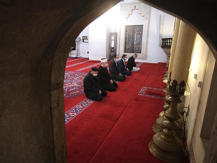 Islamische Geistliche mit Mundschutz beten in einer Moschee in Sarajevo (Bosnien-Herzegowina).