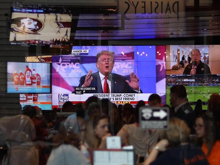 Die Rede Donlad Trumps wird im Konferenzsaal in Oxon Hill auf Monitoren übertragen.