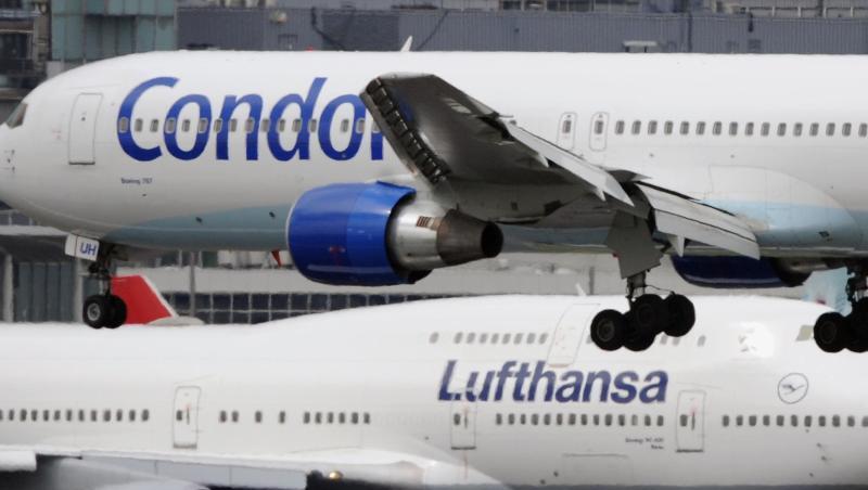 Eine Boeing 747 der Lufthansa rollt in Frankfurt zu ihrer Parkposition, während eine Boeing 757 der Condor gerade landet.