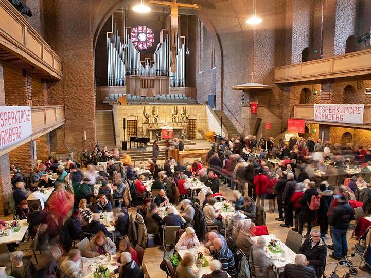 Besucher der Vesperkirche stehen an der Essenausgabe. Foto: Daniel Karmann/dpa
