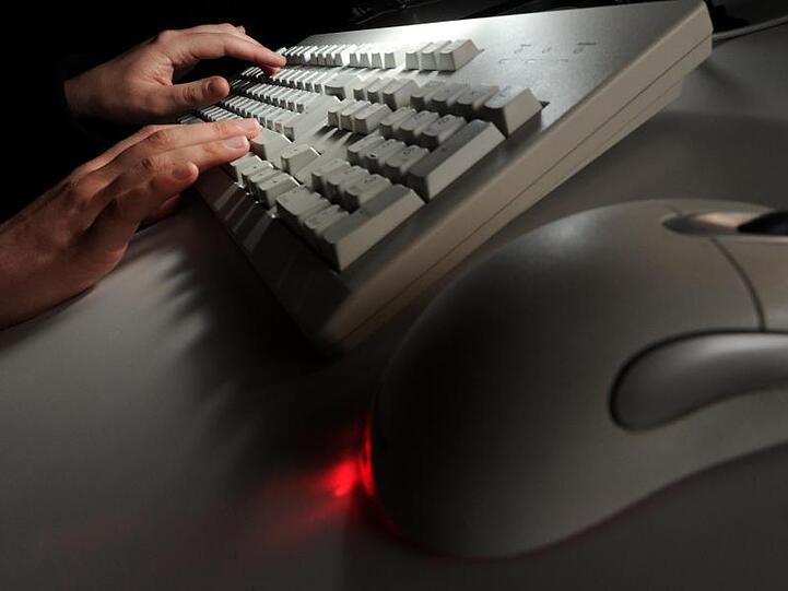 Eine Person tippt auf einer Computertastatur. Foto: Jochen Lübke/dpa/Archivbild