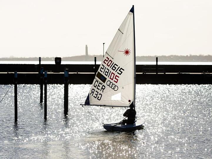 Ein Jugendlicher nutzt das Frühlingswetter in Kiel für eine Segeltour.