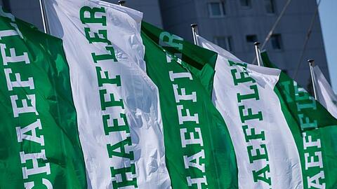 Fahnen mit dem Schriftzug der Schaeffler AG wehen. Foto: Daniel Karmann/dpa