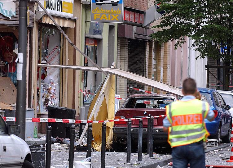 Ein Polizist sichert in Köln die Spuren einer Explosion in der Keupstraße (Archivfoto vom 09.06.2004)