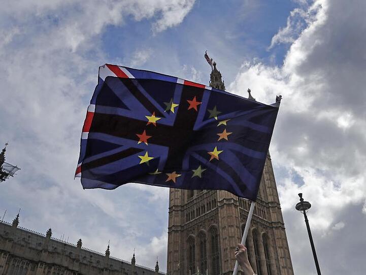 Ein Demonstrant schwenkt eine britische und eine EU-Fahne vor den Parlamentsgebäuden in Westminster.