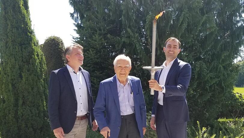 Tyczka-Firmensprecher Ulrich Hanke, Hans-Wolfgang Tyczka und sein Sohn, Frederick Tyczka-Christoph, der eine originale olympischeFackel hält.
