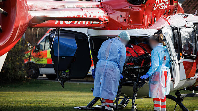 Rettungskräfte verladen einen Covid-19-Intensivpatienten aus einem Hubschrauber der Luftrettung auf einem Sportplatz in ein Fahrzeug vom Rettungsdienst. (Archivbild)