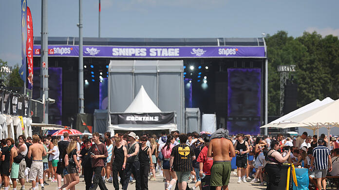 Festivalbesucher stehen an der Messe Riem auf dem Gelände des Rolling Loud-Festivals vor der Snipes-Stage.